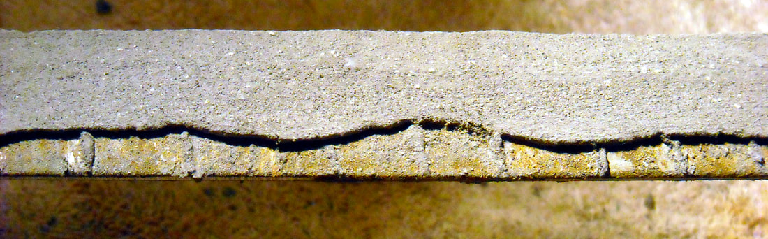 A section of blade blank prepared with dried clay in a wavy pattern.